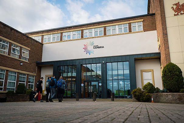 The front of Deeside college with students walking into the main entrance