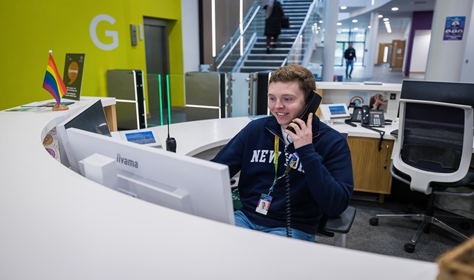 A member of staff inside Hafod at Yale side working at reception