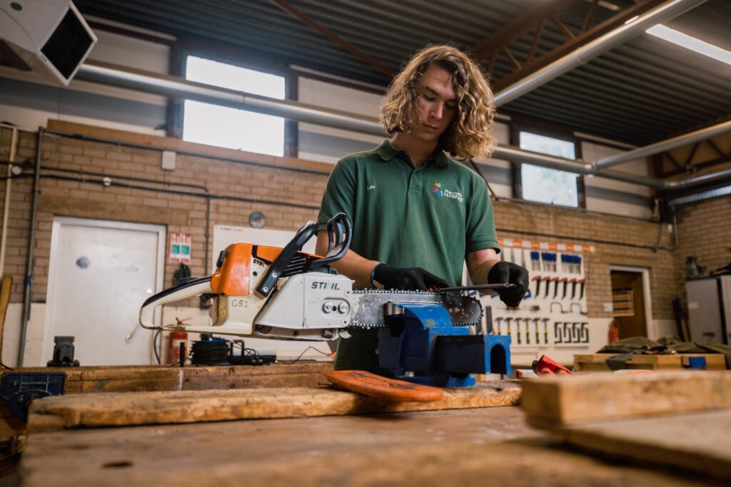 A forestry student using a chainsaw in a clamp