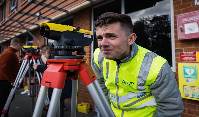A HE student on a Construction course looking into a piece of construction equipment