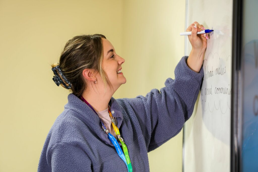 HE student writing on a whiteboard