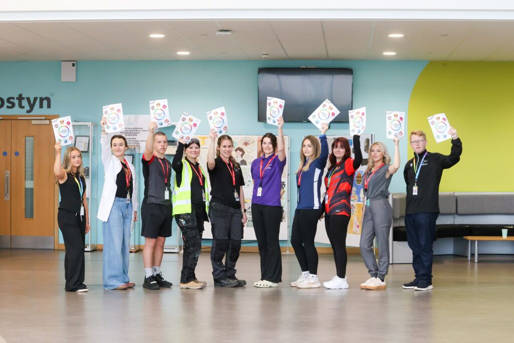 a group of students in Deeside Sixth Form holding the new strategic plan