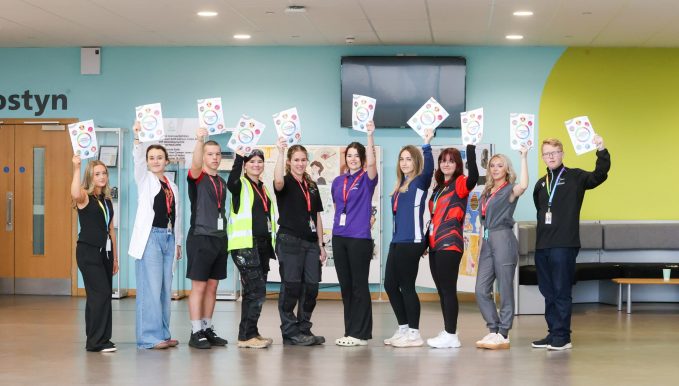 a group of students in Deeside Sixth Form holding the new strategic plan